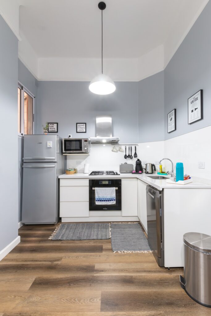 Imagem de uma cozinha pequena com um tapete próximo aos armários da pia